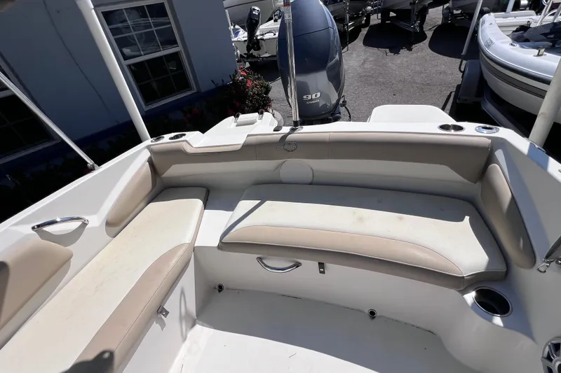 Slide: The Image of 2017 Stingray 182 SC boat interior with beige seating and outboard motor. - 12
