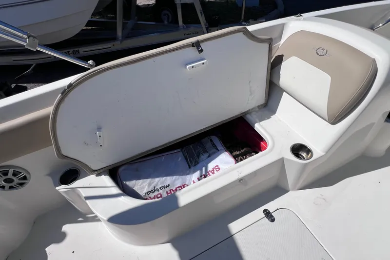 Slide: The Image of 2017 Stingray 182 SC boat interior with open storage compartment and seating area. - 15