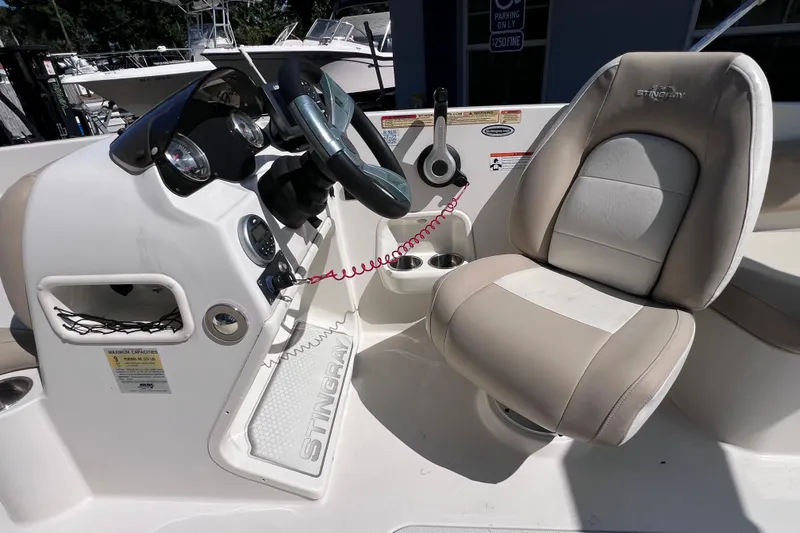 Slide: The Image of 2017 Stingray 182 SC boat cockpit with steering wheel and cushioned seat. - 18