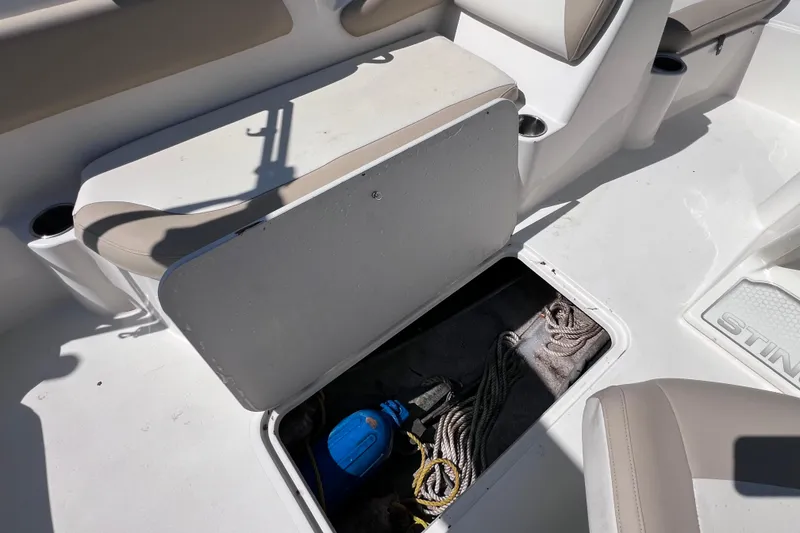 Slide: The Image of Open storage compartment on 2017 Stingray 182 SC boat, revealing ropes and equipment. - 23