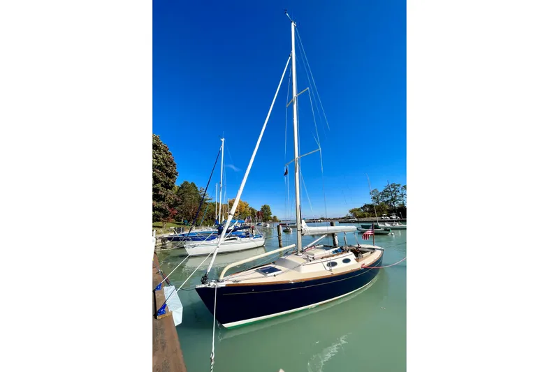 Slide: The Image of 2012 Alerion Express 28 sailboat docked in a serene marina under clear blue skies. - 21