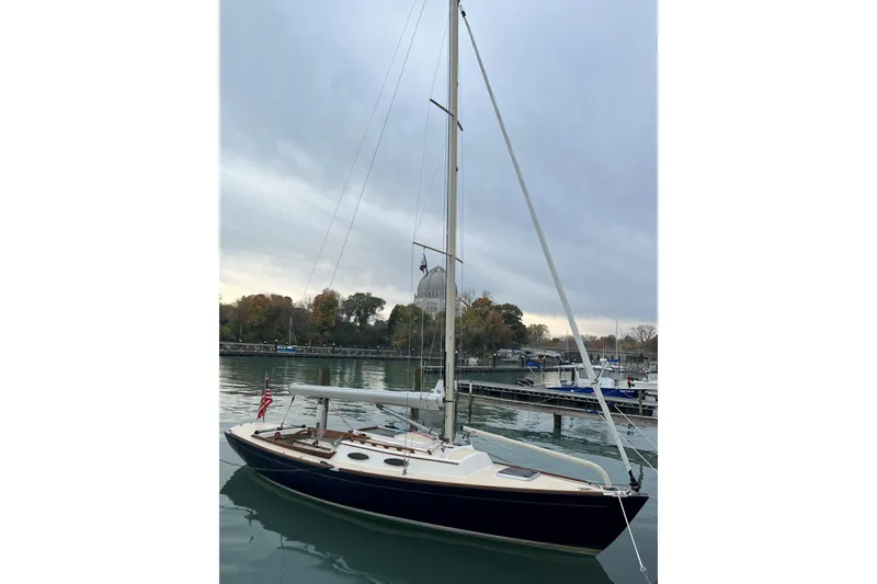 Slide: The Image of 2012 Alerion Express 28 sailboat docked on a calm lake under cloudy skies. - 22