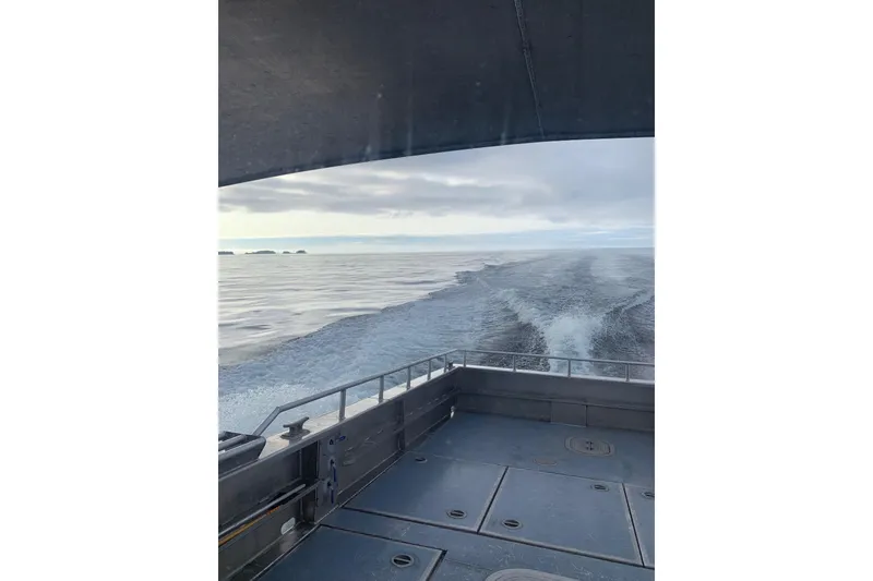 Slide: The Image of Custom 2021 Aluminum Crabber boat cruising on open sea under cloudy sky. - 16