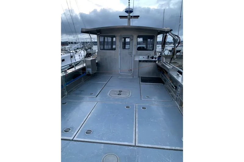 Slide: The Image of Custom 2021 Aluminum Crabber boat with spacious deck and cabin, docked at marina. - 21