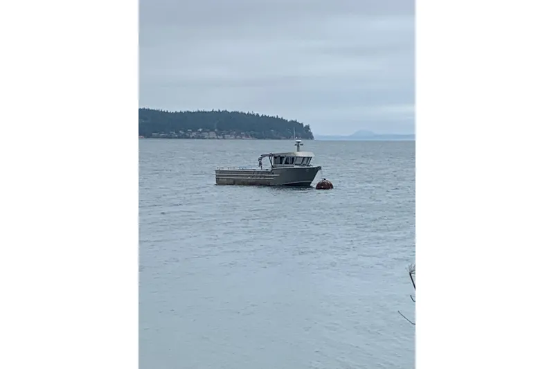 Slide: The Image of A 2021 Custom Aluminum Crabber boat anchored in a calm bay. - 25