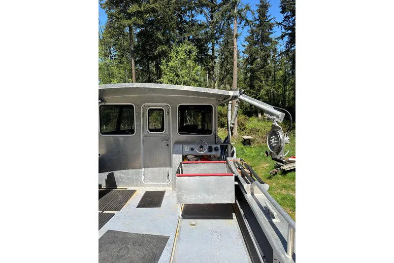 Slide: The Image of Custom 2021 Aluminum Crabber boat with crane, docked in a forested area. - 9