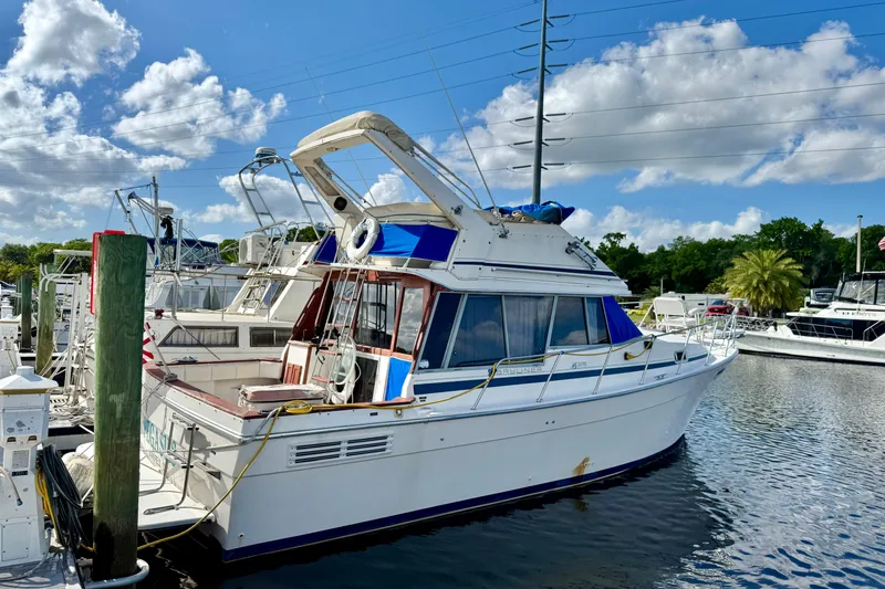The Image of 1988 Bayliner 3218 Motoryacht docked at marina under blue sky. - 0