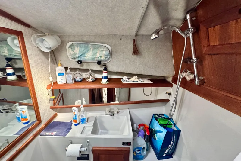 Slide: The Image of 1988 Bayliner 3218 Motoryacht bathroom with sink, toiletries, and showerhead. - 10