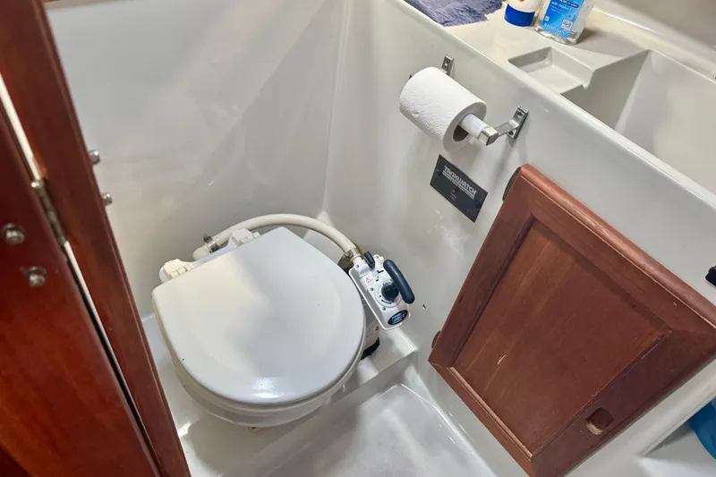 Slide: The Image of 1988 Bayliner 3218 Motoryacht bathroom with marine toilet and wooden cabinet. - 11