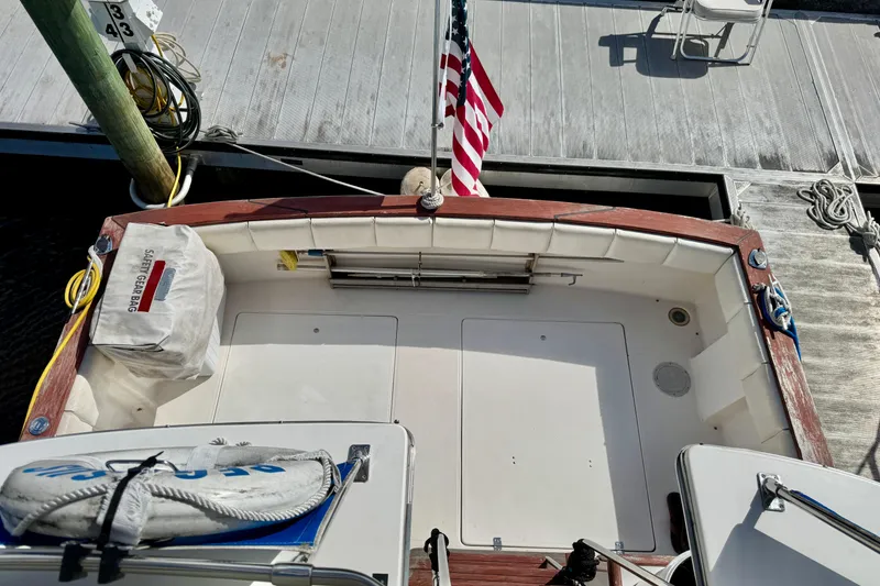 Slide: The Image of 1988 Bayliner 3218 Motoryacht docked, featuring deck area with safety gear and American flag. - 16