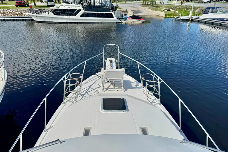 Slide: The Image of 1988 Bayliner 3218 Motoryacht docked in a marina, viewed from the bow. - 2