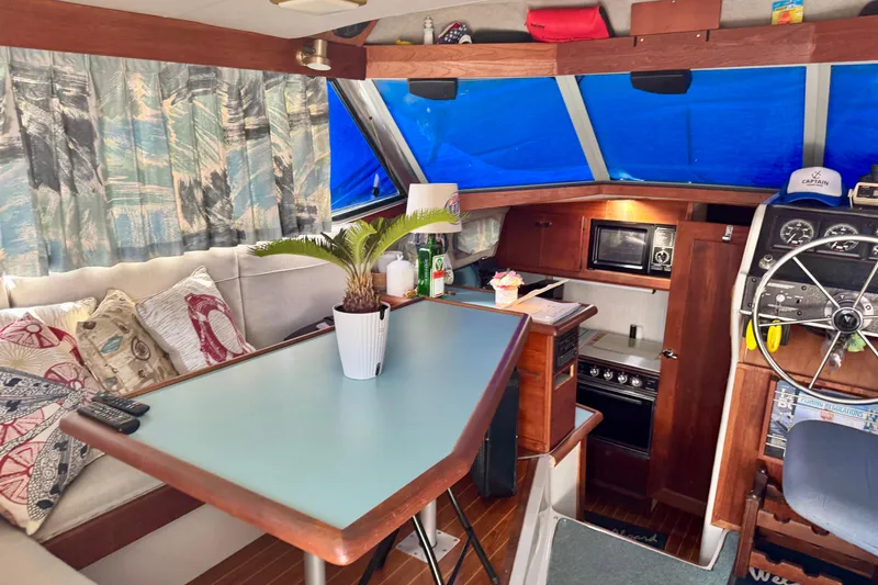Slide: The Image of Interior of a 1988 Bayliner 3218 Motoryacht with cozy seating and nautical decor. - 4