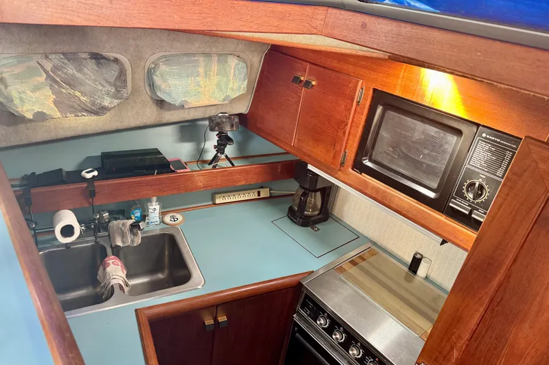Slide: The Image of 1988 Bayliner 3218 Motoryacht kitchen with sink, stove, and microwave. - 6
