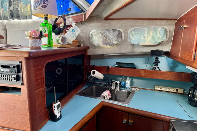 Slide: The Image of 1988 Bayliner 3218 Motoryacht interior with kitchenette, sink, and wooden cabinetry. - 7