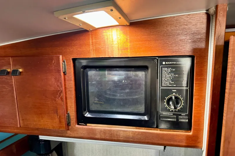 Slide: The Image of 1988 Bayliner 3218 Motoryacht interior with Sanyo microwave and wooden cabinetry. - 9