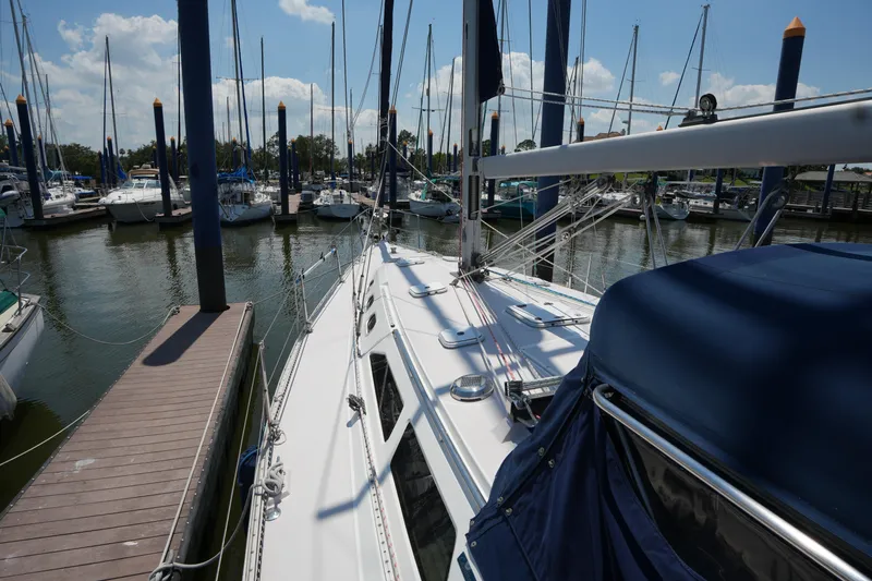 Slide: The Image of 2003 Catalina 400 MkII sailboat docked at marina, surrounded by other boats under a clear sky. - 11