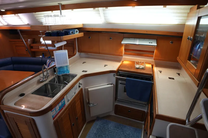 Slide: The Image of Interior of 2003 Catalina 400 MkII yacht kitchen with wooden cabinetry and modern amenities. - 21