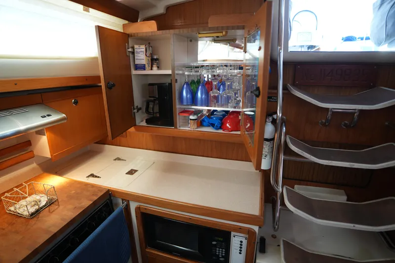 Slide: The Image of 2003 Catalina 400 MkII yacht interior kitchen with cabinets, microwave, and countertop. - 23