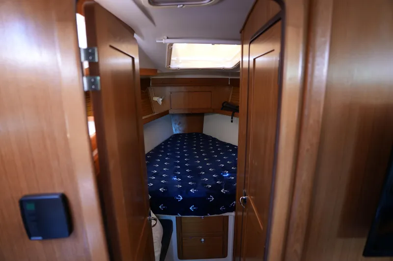Slide: The Image of Cozy cabin interior of 2003 Catalina 400 MkII sailboat with wooden finish and nautical bedding. - 24
