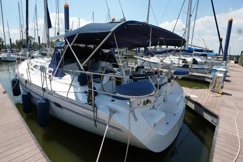 Slide: The Image of Catalina 400 MkII 2003 sailboat docked at marina, featuring blue canopy and sleek design. - 5