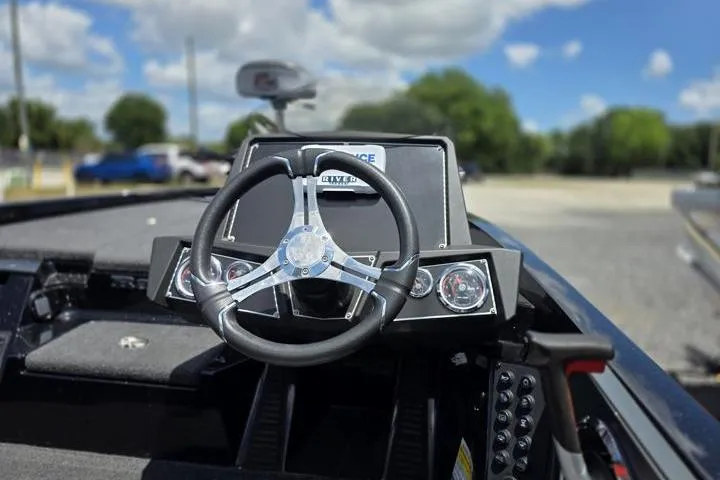 Slide: The Image of 2024 Ranger Z518 Cup-Equipped boat dashboard with steering wheel, outdoors under blue sky. - 23