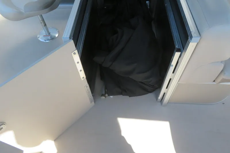 Slide: The Image of Open storage compartment on 2015 Avalon GS 2185 RF boat with black cover inside. - 18