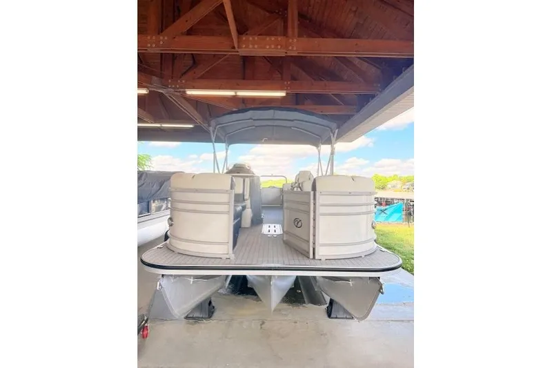 Slide: The Image of 2019 Veranda VP25RC pontoon boat under wooden shelter, showcasing spacious seating. - 7