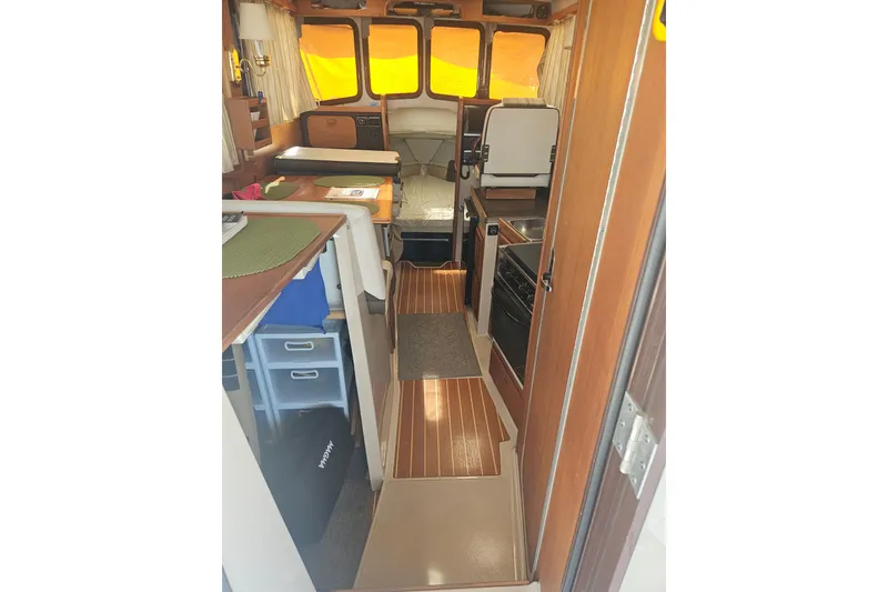 Slide: The Image of Interior of 2014 Ranger Tugs R-27 boat with wood accents and compact kitchen. - 10
