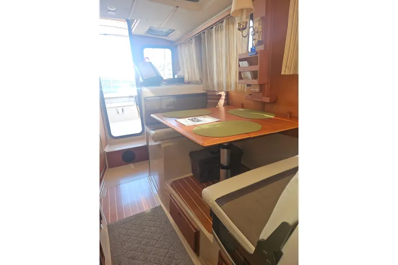 Slide: The Image of Interior of 2014 Ranger Tugs R-27 boat with dining area and wooden accents. - 12