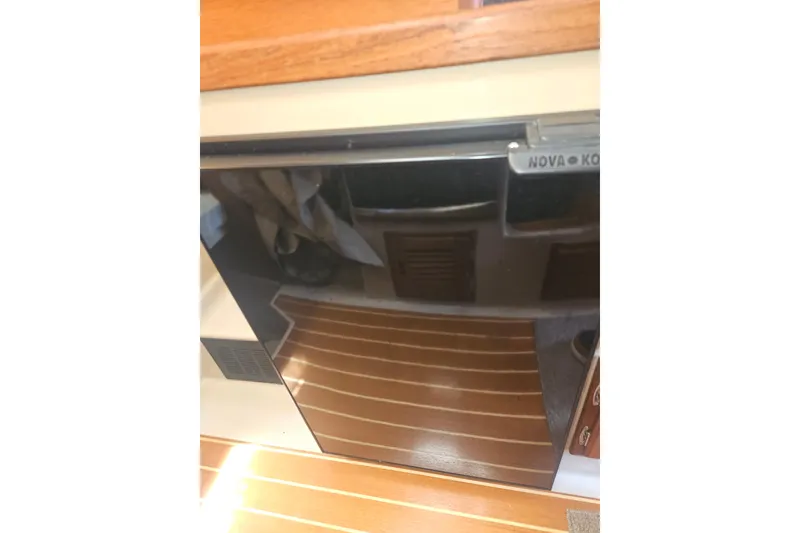 Slide: The Image of Nova Kool refrigerator inside 2014 Ranger Tugs R-27 boat, with wooden flooring. - 17