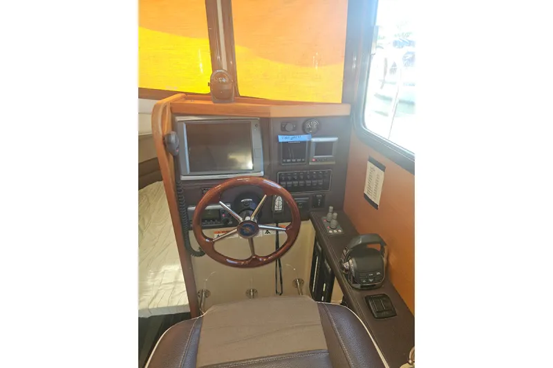 Slide: The Image of Interior helm of 2014 Ranger Tugs R-27 with steering wheel and navigation controls. - 18