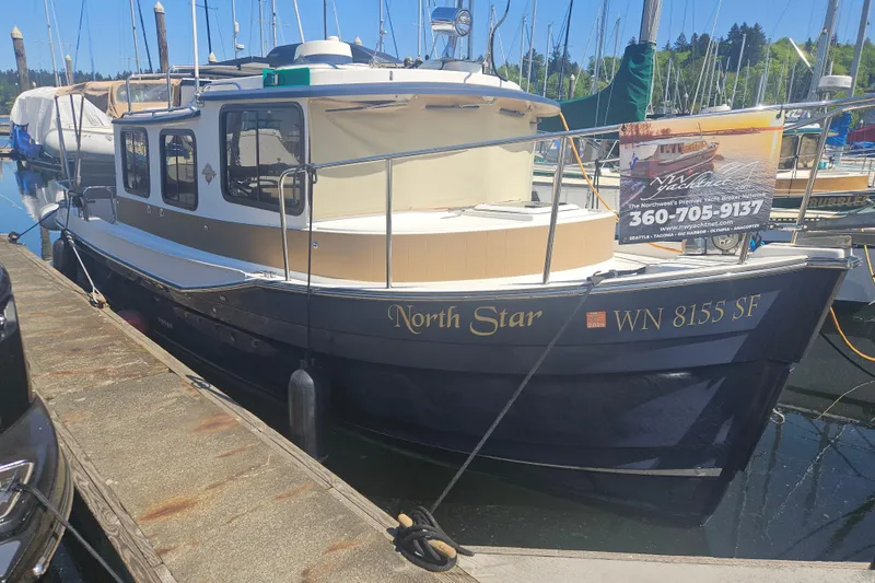 Slide: The Image of 2014 Ranger Tugs R-27 boat named "North Star" docked at a marina. - 2