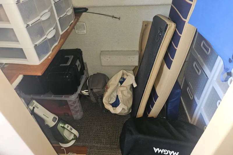 Slide: The Image of Storage area inside a 2014 Ranger Tugs R-27 boat with organized shelves and equipment. - 21
