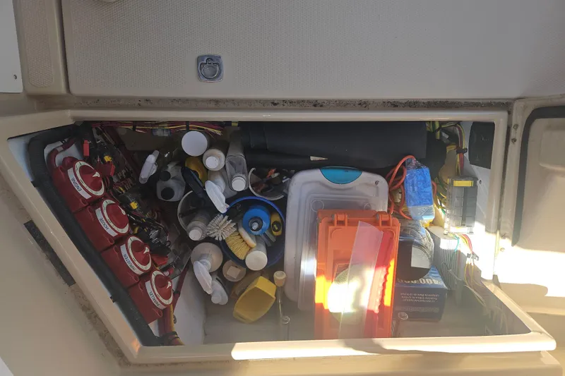 Slide: The Image of Storage compartment of a 2014 Ranger Tugs R-27 boat, filled with various maintenance supplies. - 43