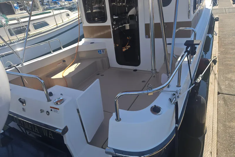 Slide: The Image of 2014 Ranger Tugs R-27 boat docked, showcasing spacious deck and sleek design. - 5