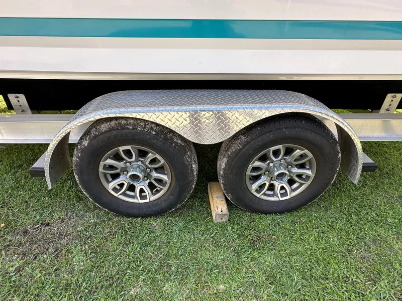 Slide: The Image of 2024 Blackfin 252 DC boat trailer with dual wheels on grass. - 6