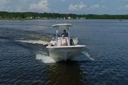 Slide: The Image of Manufacturer Provided Image: 2026 Carolina Skiff 23 LS boat cruising on a calm lake under a clear sky. - 11