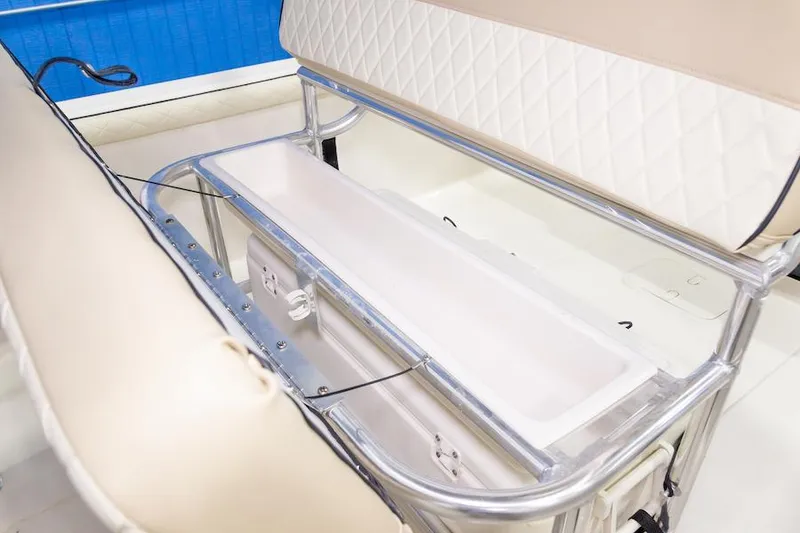 Slide: The Image of Manufacturer Provided Image: 2026 Carolina Skiff 23 LS boat seating with storage compartment, featuring beige upholstery and stainless steel frame. - 15