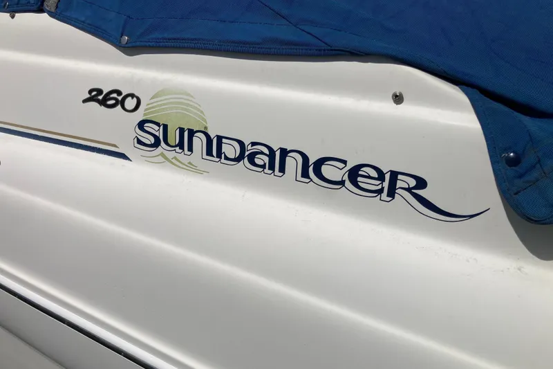 Slide: The Image of 2002 Sea Ray Sundancer 260 boat with blue cover and logo detailing. - 10