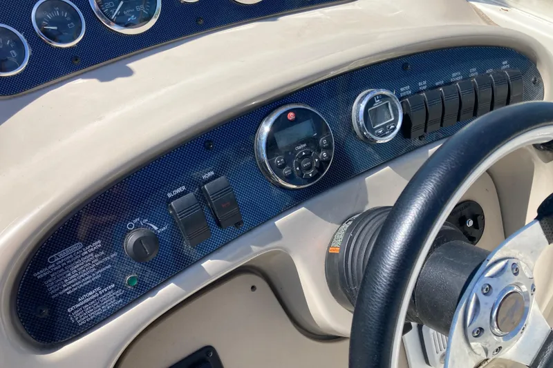 Slide: The Image of 2002 Sea Ray Sundancer 260 dashboard with gauges, switches, and steering wheel. - 17