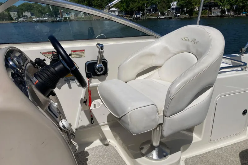 Slide: The Image of Captain's seat and helm of a 2002 Sea Ray Sundancer 260 boat, overlooking water. - 19