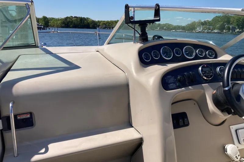 Slide: The Image of 2002 Sea Ray Sundancer 260 boat dashboard with gauges, steering wheel, and lake view. - 24