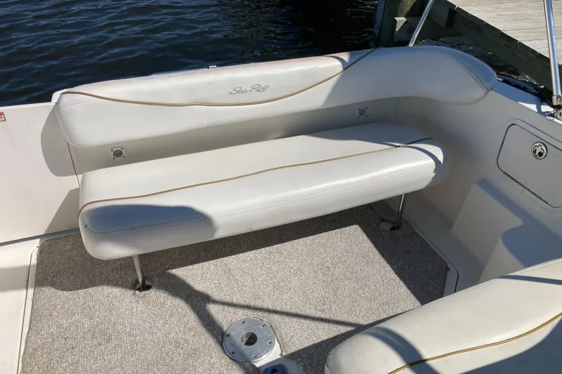 Slide: The Image of 2002 Sea Ray Sundancer 260 boat interior with white cushioned seating and carpeted floor. - 26