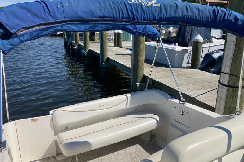 Slide: The Image of 2002 Sea Ray Sundancer 260 boat interior with blue canopy at dockside. - 27