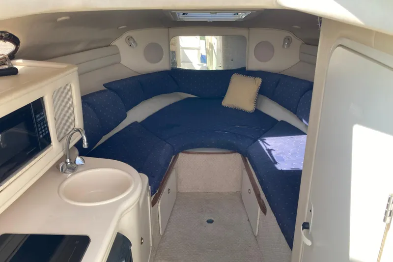 Slide: The Image of Interior of 2002 Sea Ray Sundancer 260 with kitchenette and cozy seating area. - 29