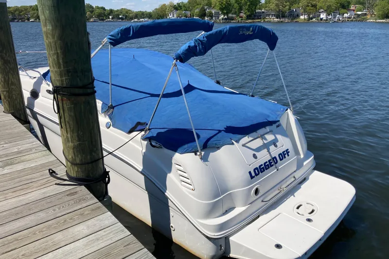 Slide: The Image of 2002 Sea Ray Sundancer 260 boat docked with blue cover on a sunny day. - 3