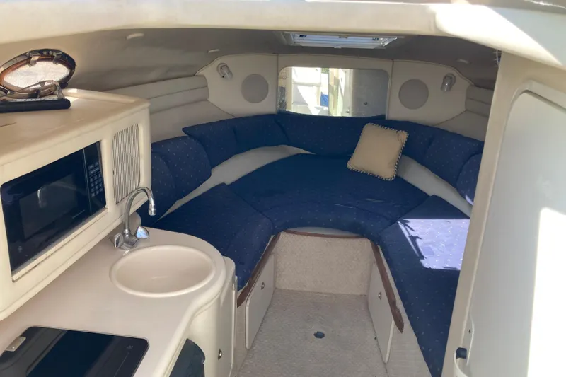 Slide: The Image of Interior of 2002 Sea Ray Sundancer 260 with kitchenette and cozy seating area. - 30