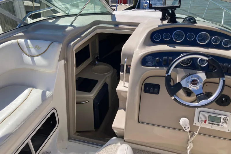 Slide: The Image of 2002 Sea Ray Sundancer 260 cockpit with steering wheel, gauges, and cabin entrance. - 31
