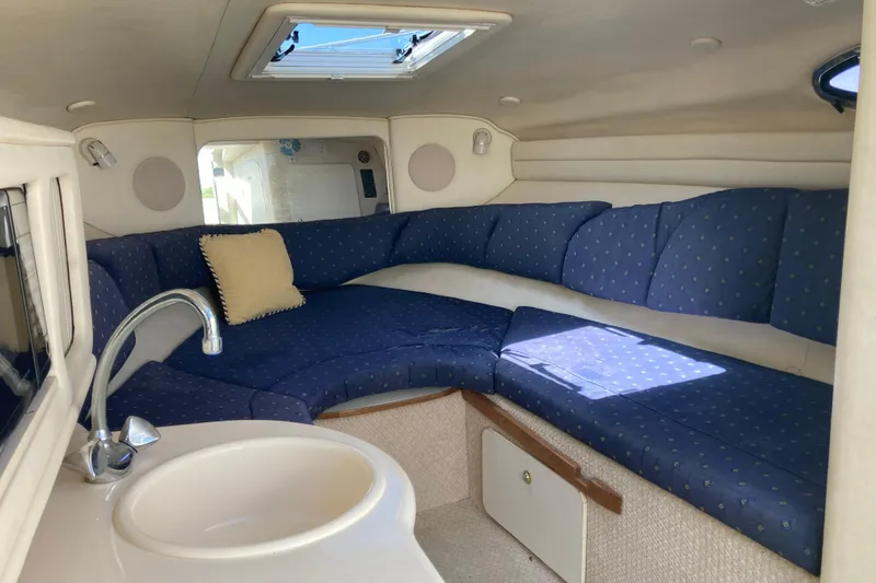 Slide: The Image of Interior of 2002 Sea Ray Sundancer 260 with blue seating and compact kitchenette. - 34