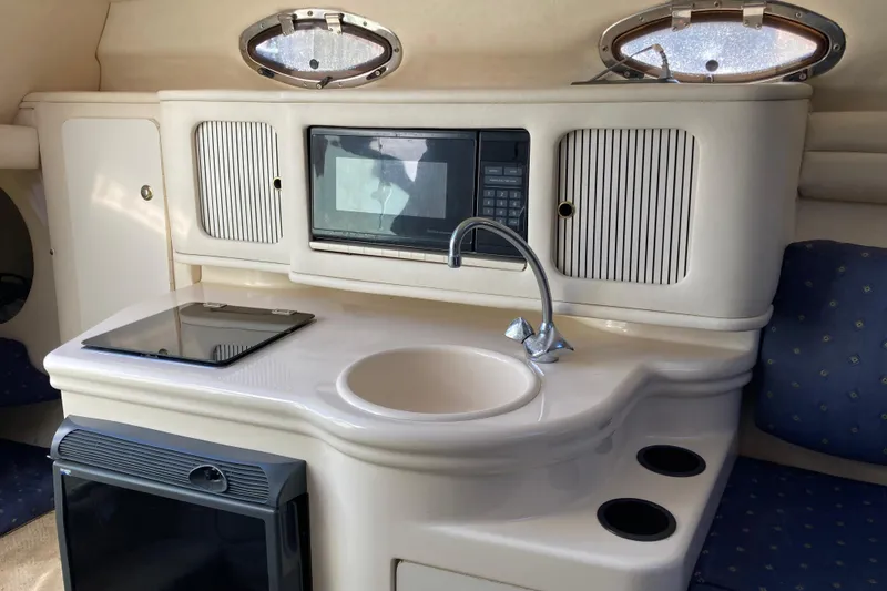 Slide: The Image of Interior of a 2002 Sea Ray Sundancer 260 boat featuring a compact kitchenette. - 37
